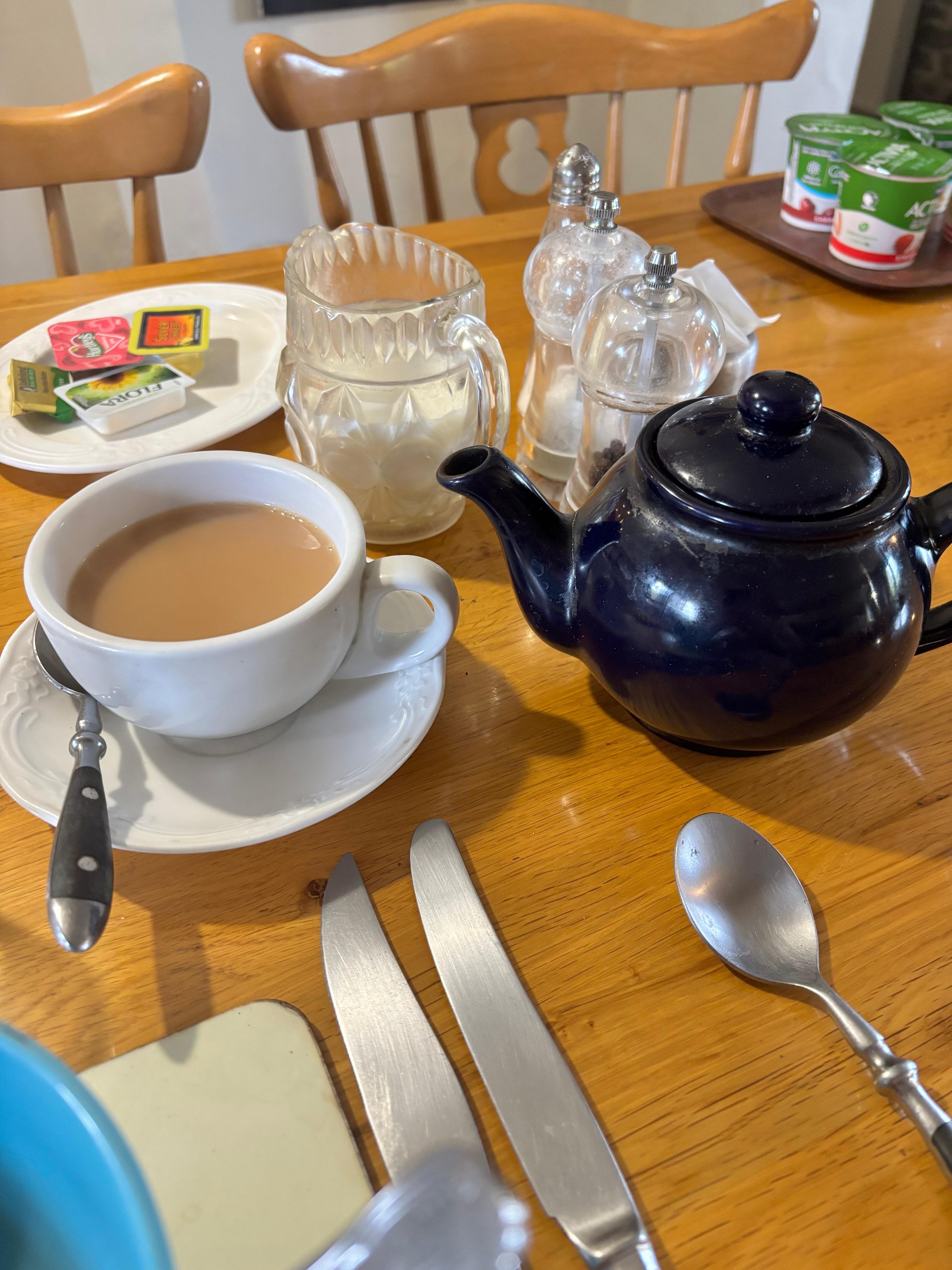 English style breakfast. Tea, juice, cereal, yoghurt, egg, toast, bacon, beans.