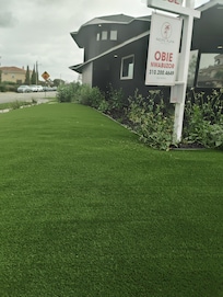 For sale sign in front of house and high weeds.