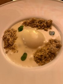 Poached egg with morels in a creamy sauce topped with pesto oil and breadcrumbs