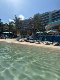 Facing resort from water. Cruise ships come in & the beach is open to those who buy the pass so it’s not as private as a beach as it seems. Gets extremely crowded & can be a struggle to find seats if needing more than one. This is before the arrival.