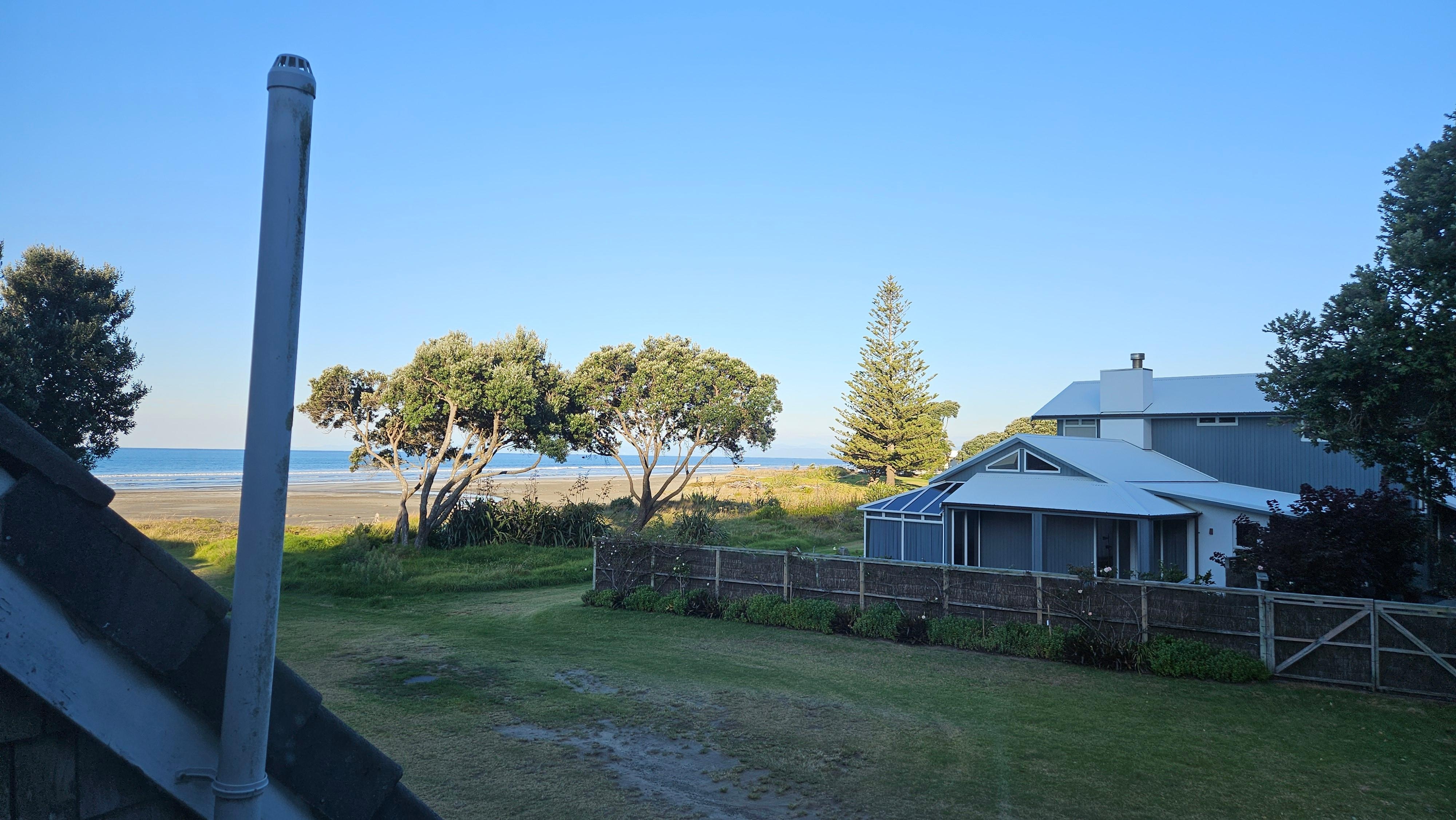 View to Ohope Beach from breakfast table. Walk across adjacent reserve space to sand and surf.