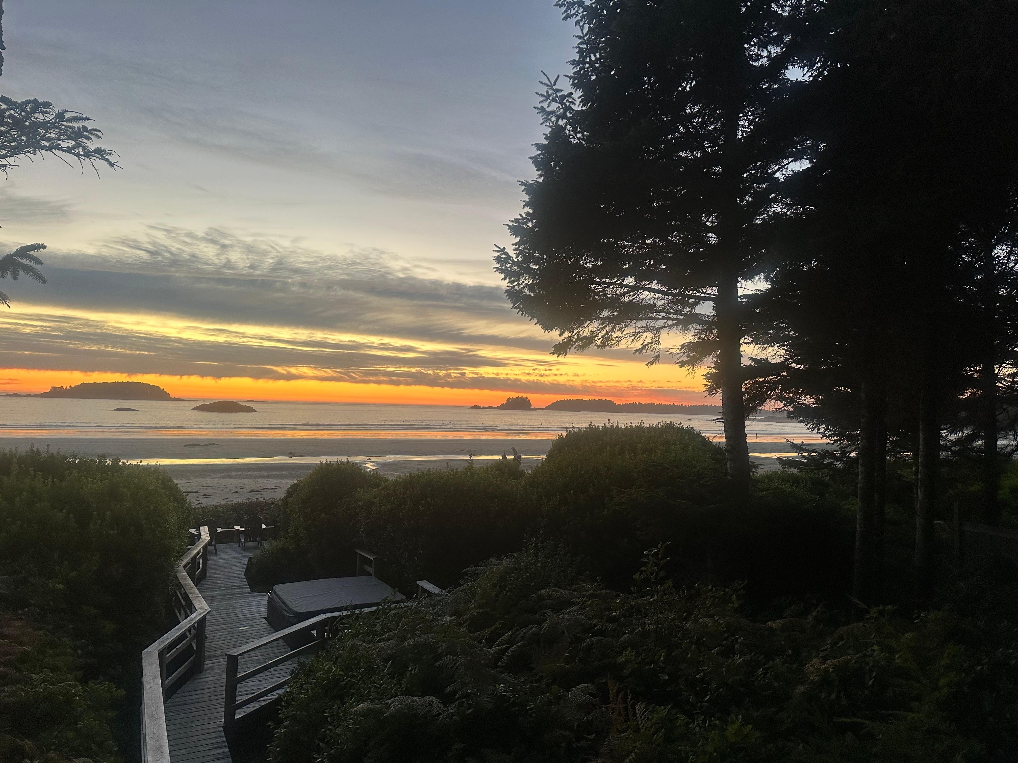 A bit of sunset taken from the outdoor dining table looking out past the home’s walkway to ocean