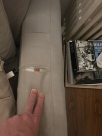 The couches have a dirty dust cover on them with one part ripped through to the inside of the couch