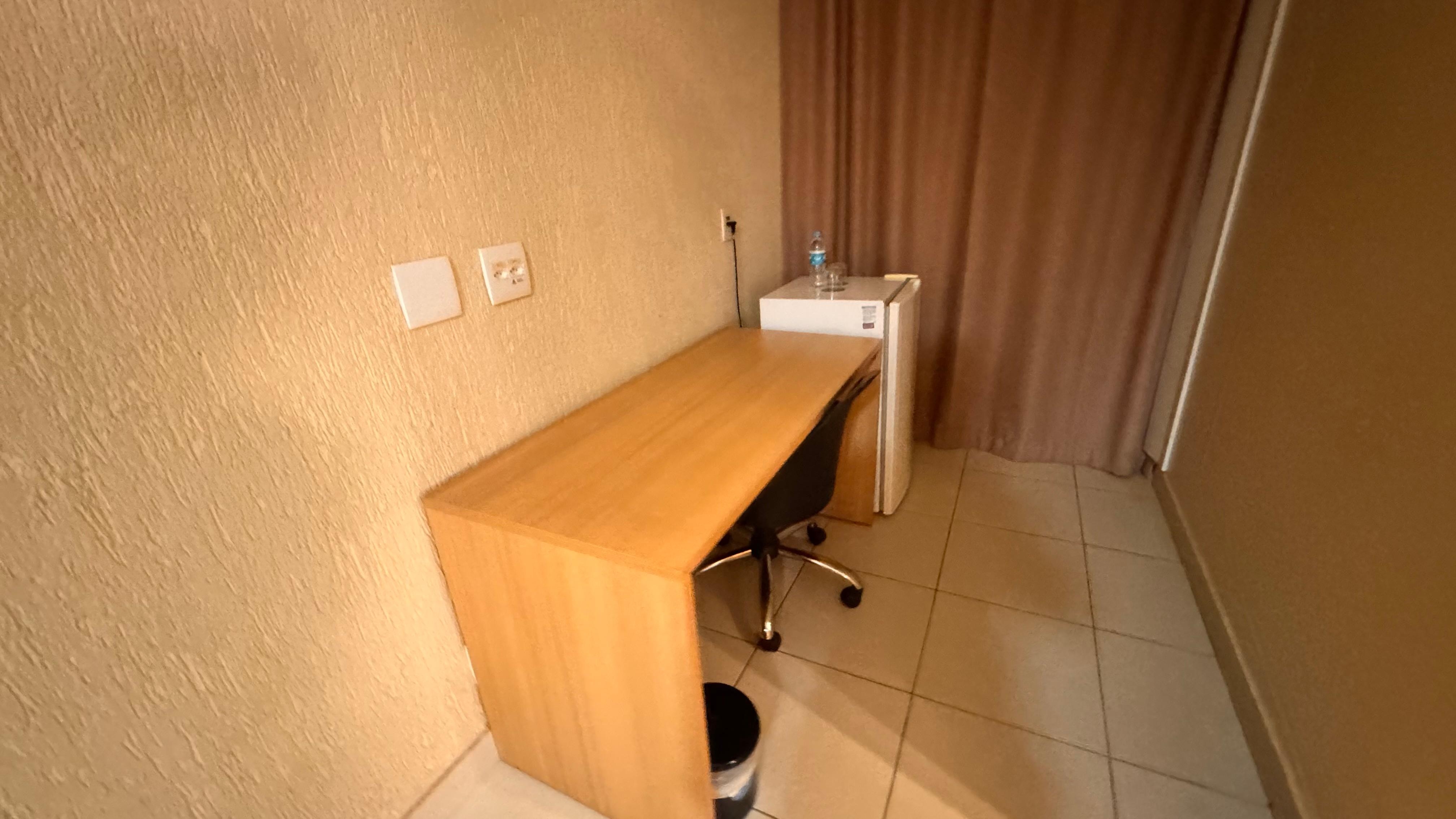 Bancada e frigobar, uma água estava em cima do frigobar como cortesia 