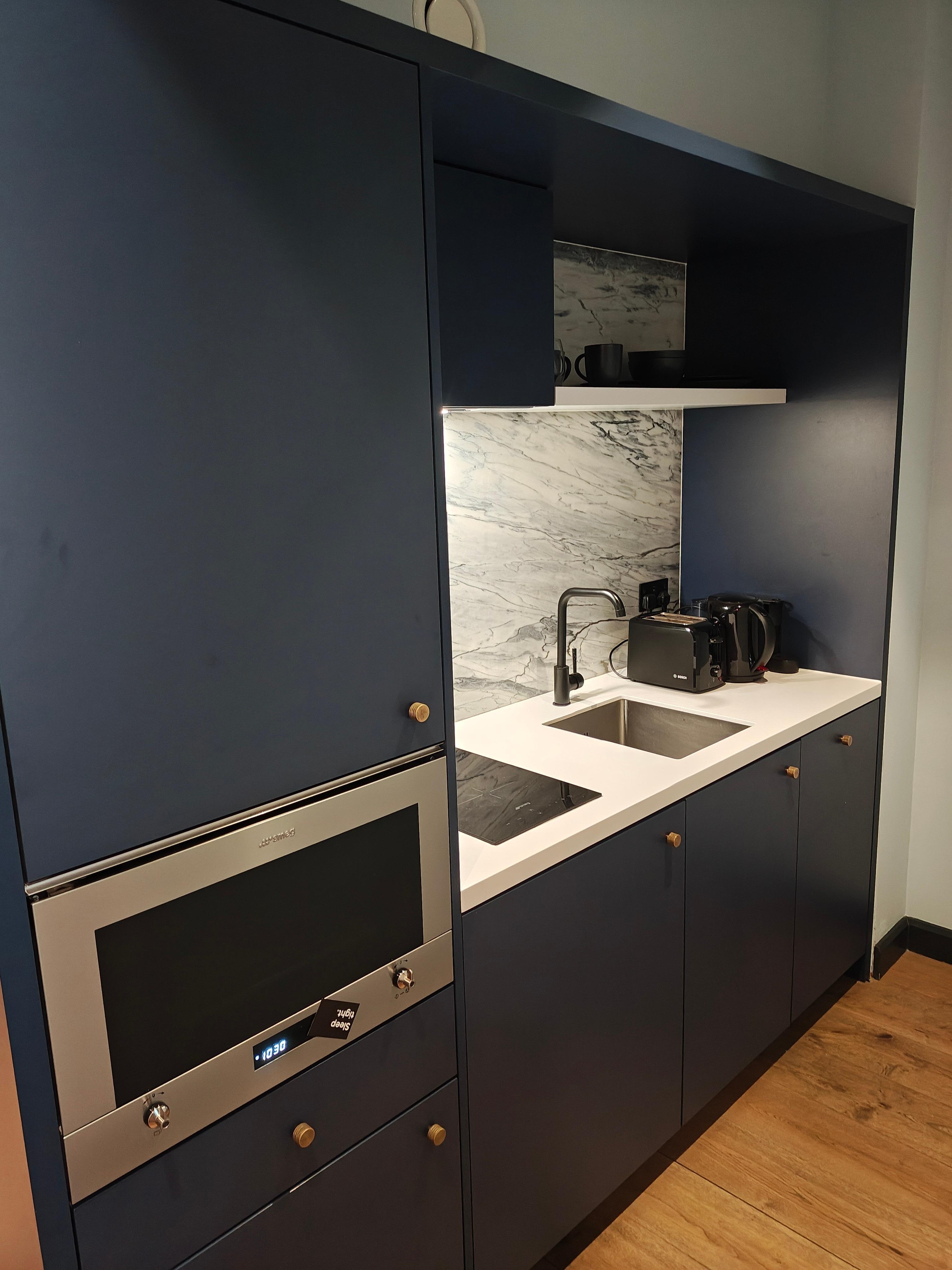 Kitchen area with wash machine and fridge 