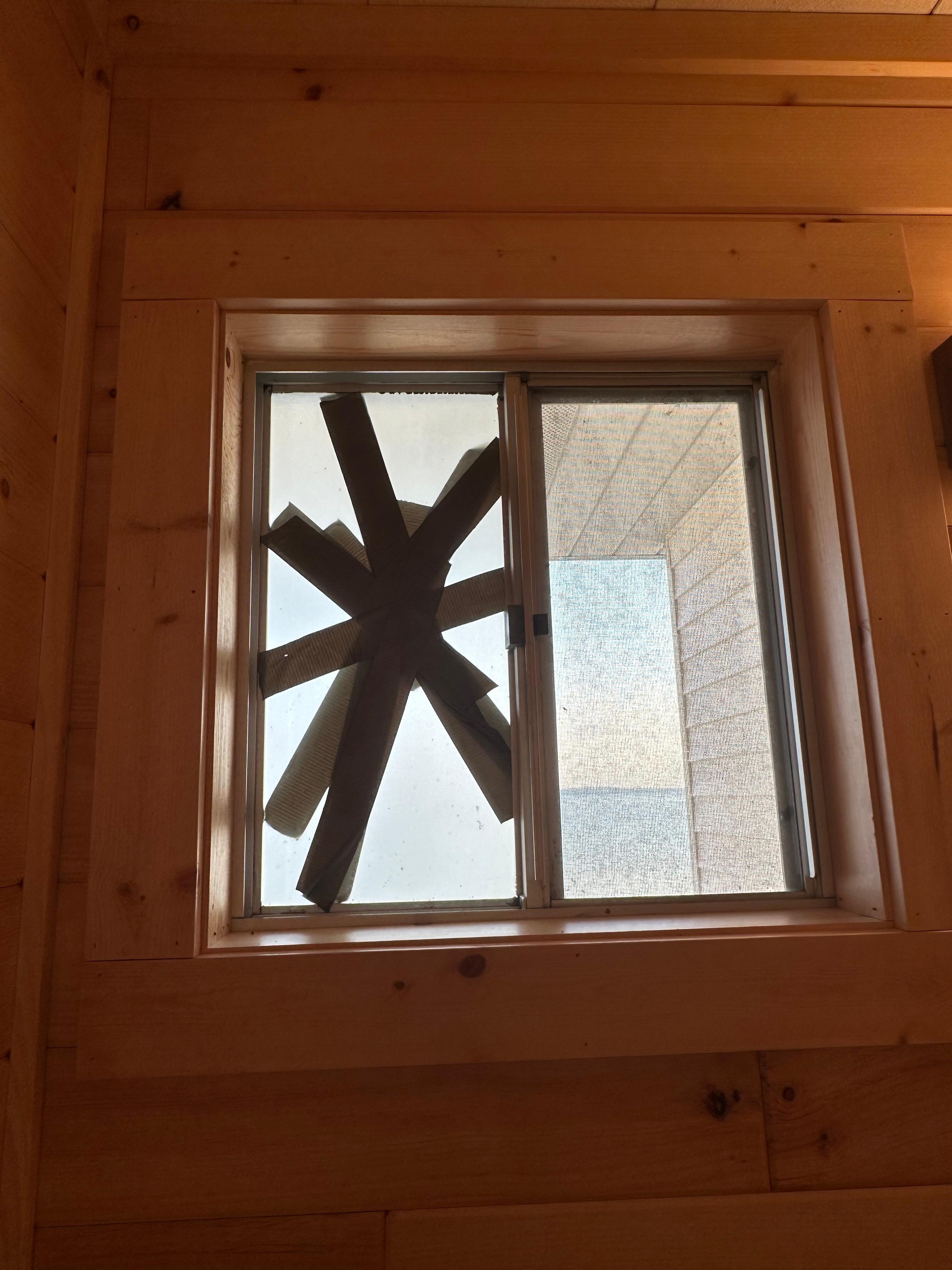 Bathroom window broken and dirty with dirt on window seal. 