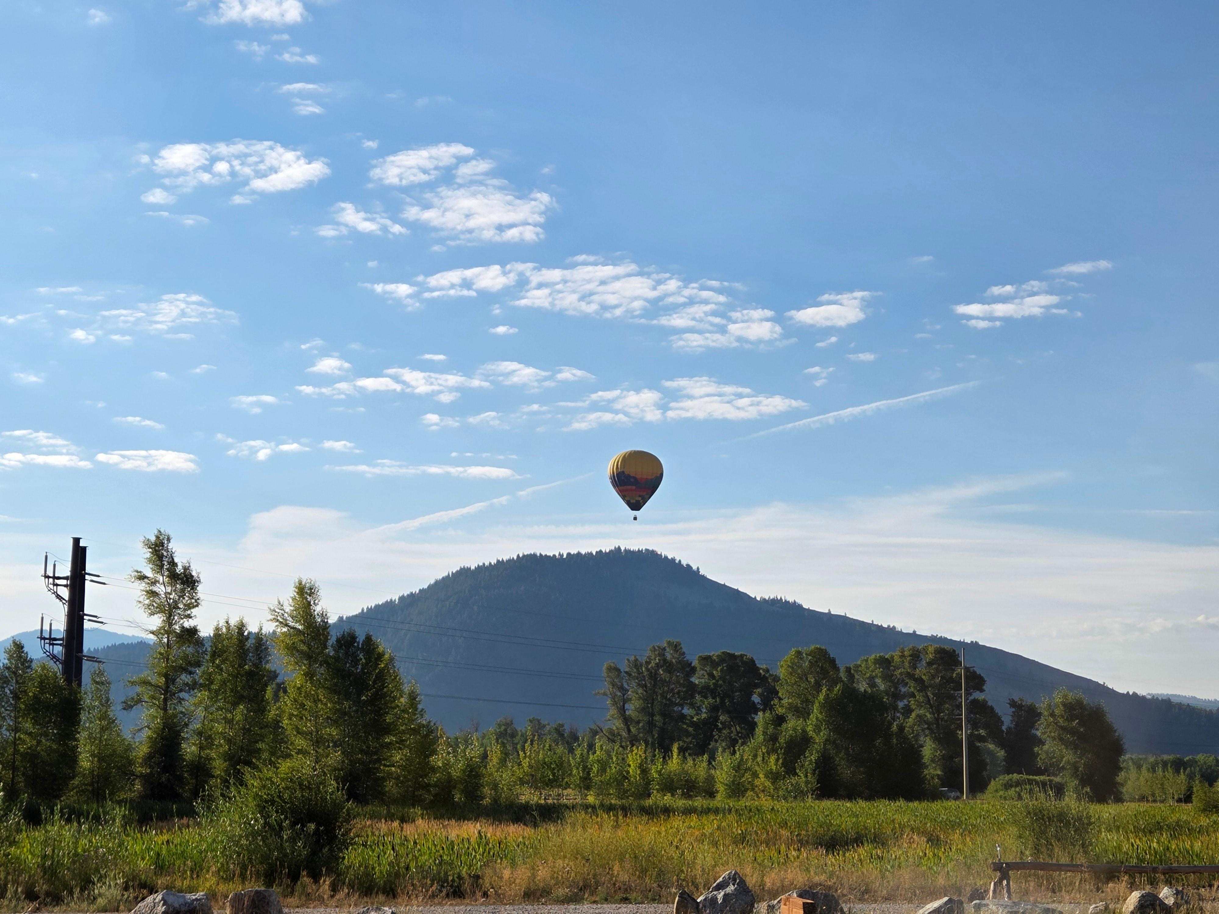 Hot air balloon sets down in the field in front 
