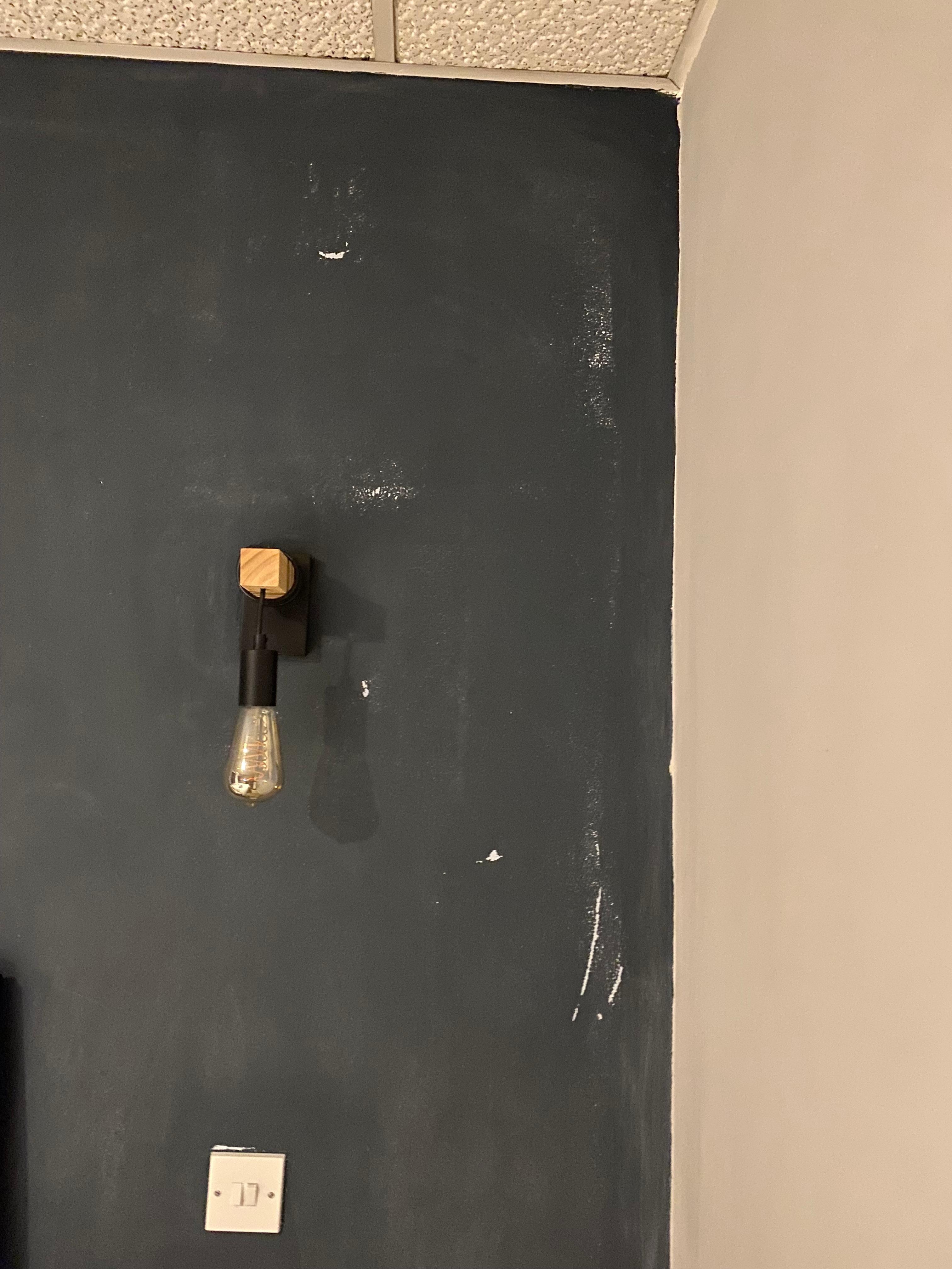 Damaged and stained wall above bed.
