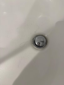 Hair/grime in tub showing bath had clearly not been cleaned