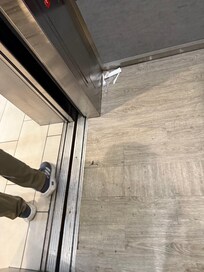 Floor is all chipped with garbage on the floor.