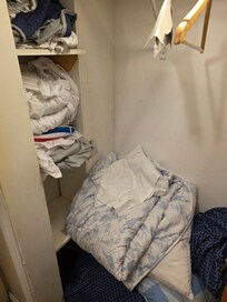 Sheets and blankets on the floor and wadded up.