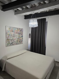 Queensize seng med overlaken og sengeteppe.