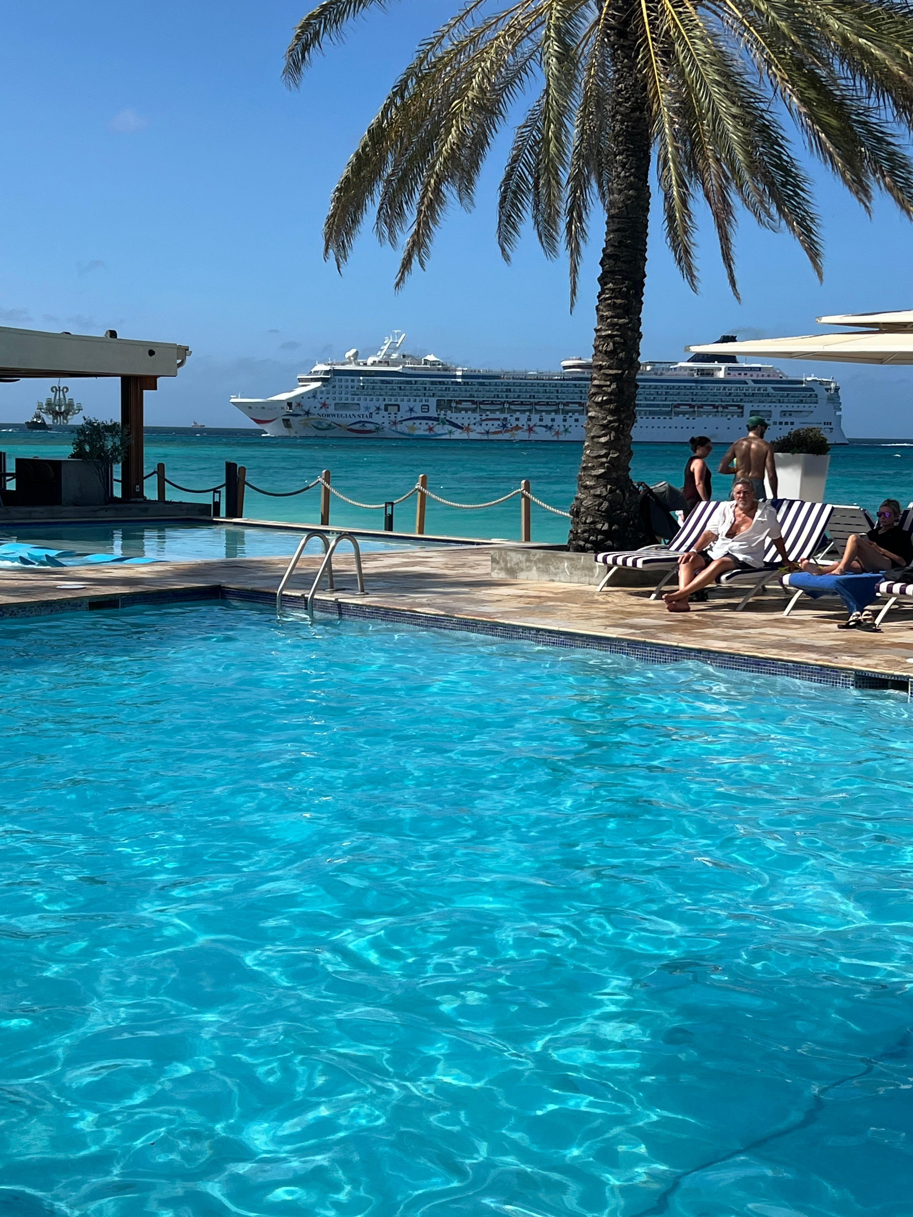 Pool with view of cruise liners entering nearby port. 