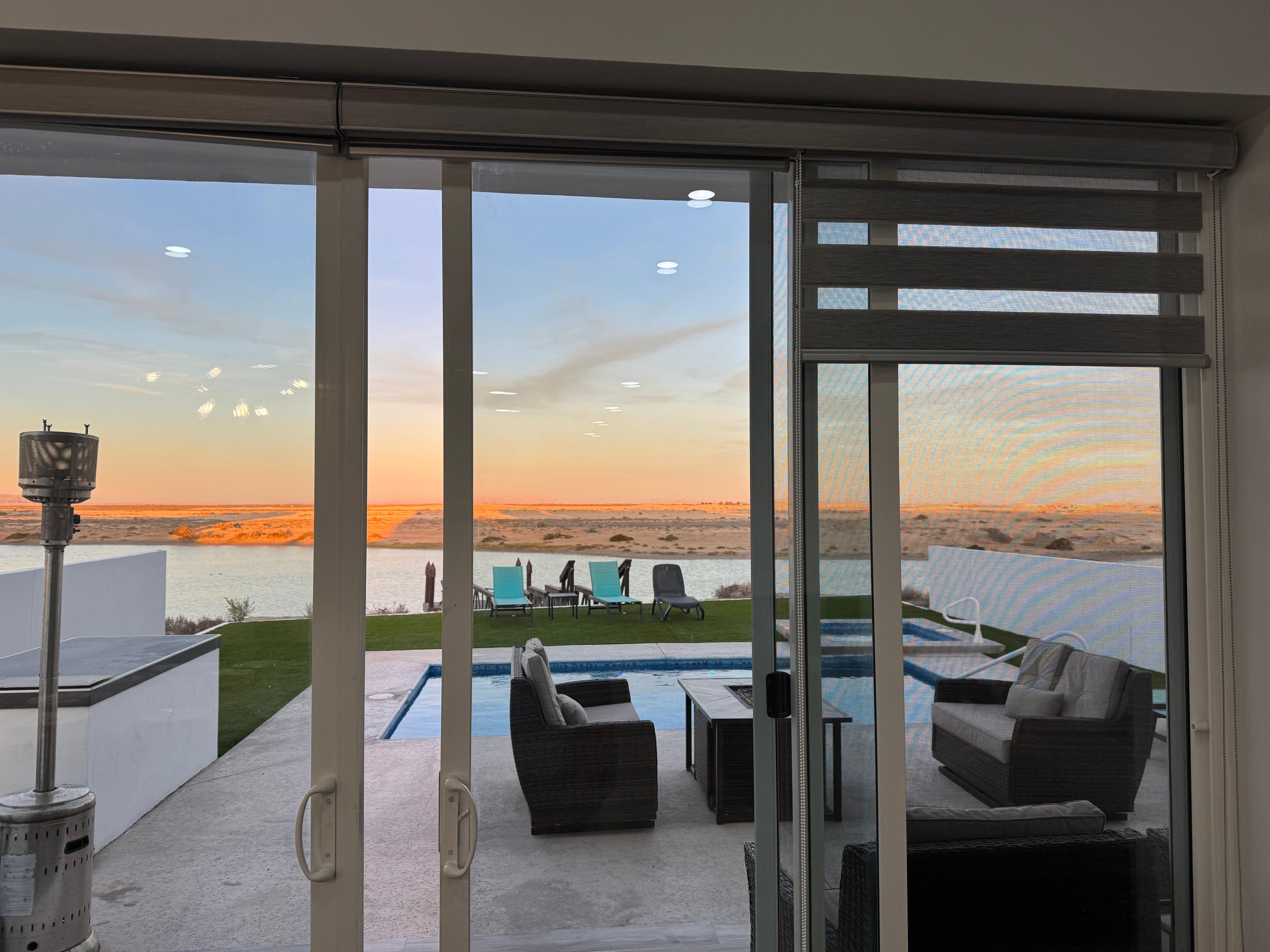 Big glass windows and doors overlooking fire table pool hot tub area.