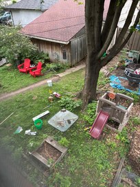 This is the backyard filled with tools, garden equipment, and some furniture, but not really