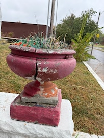 Broken steps and planters with dead plants and plastic broken flowers