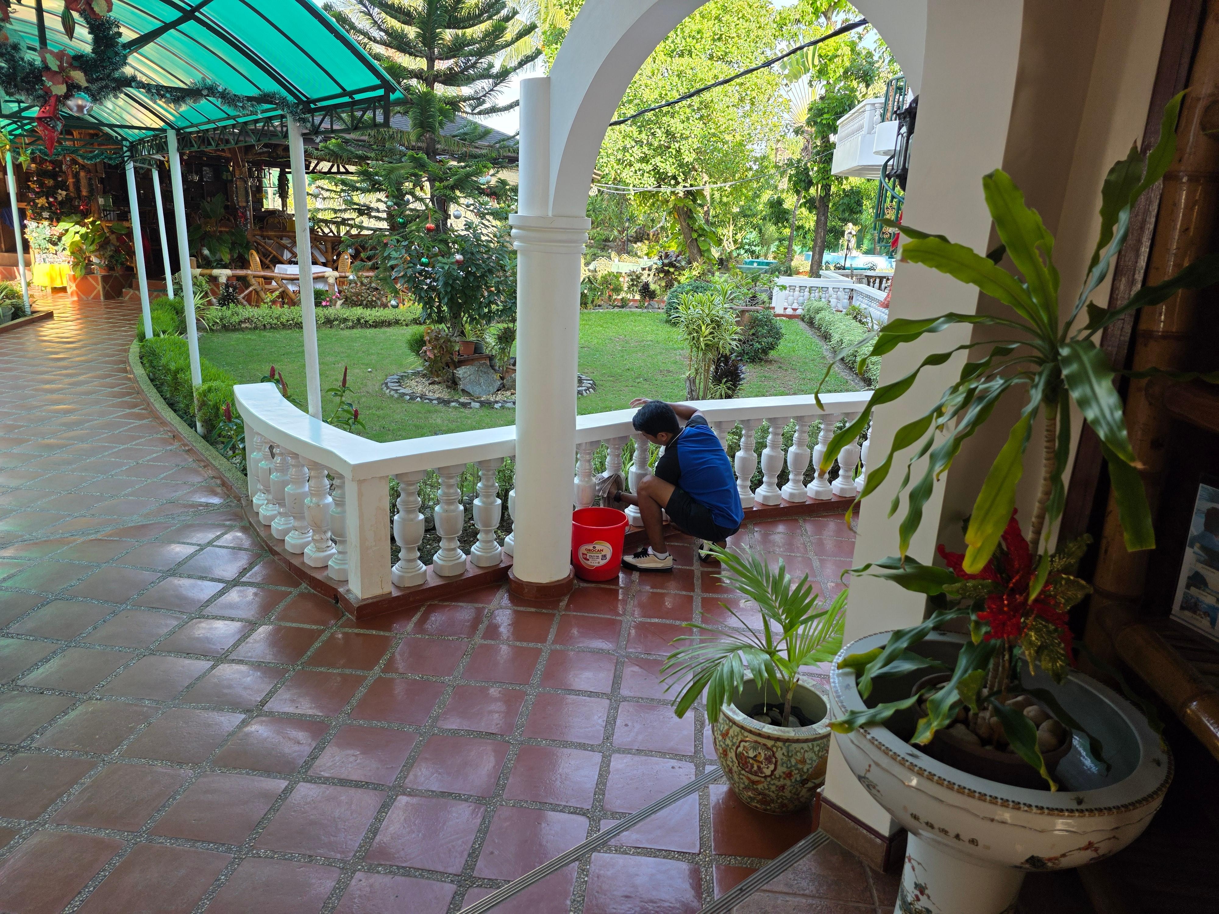 Cleaning the white cement fence by hand.