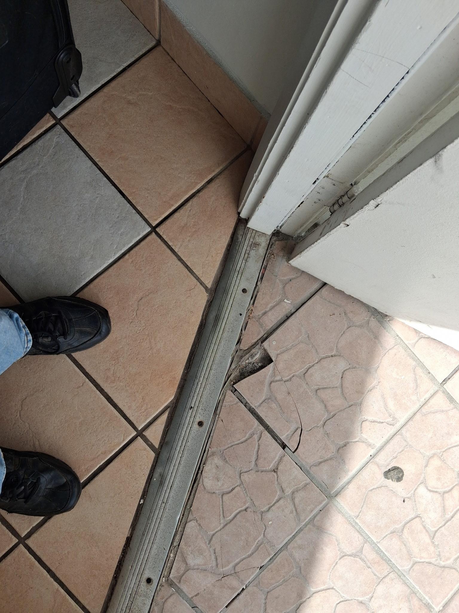 Cracked tile everywhere even by the door which was hard to open.