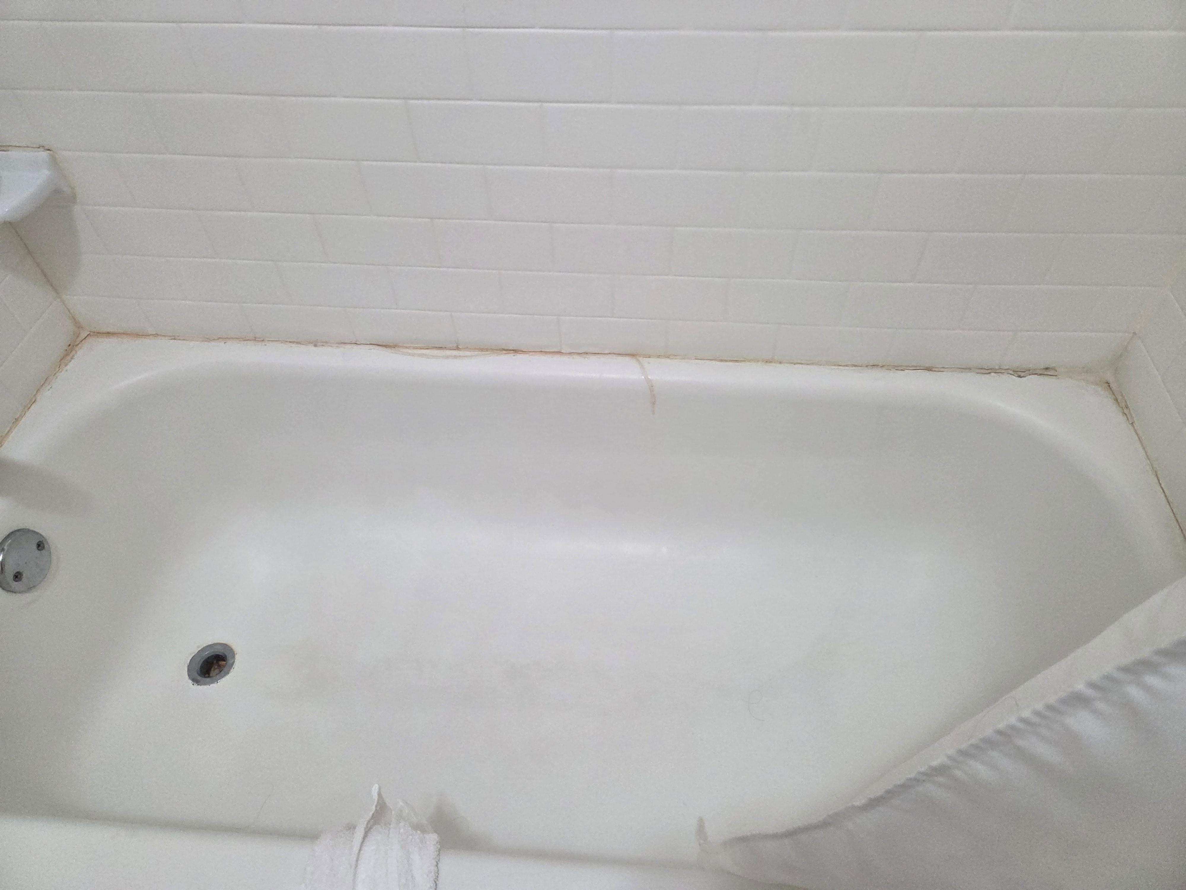 Old caulking peeling off bathtub