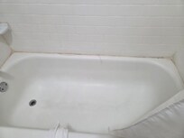 Old caulking peeling off bathtub