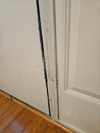 Someone's dog apparently scratched up the door frame. Repair is just a thick coat of paint.