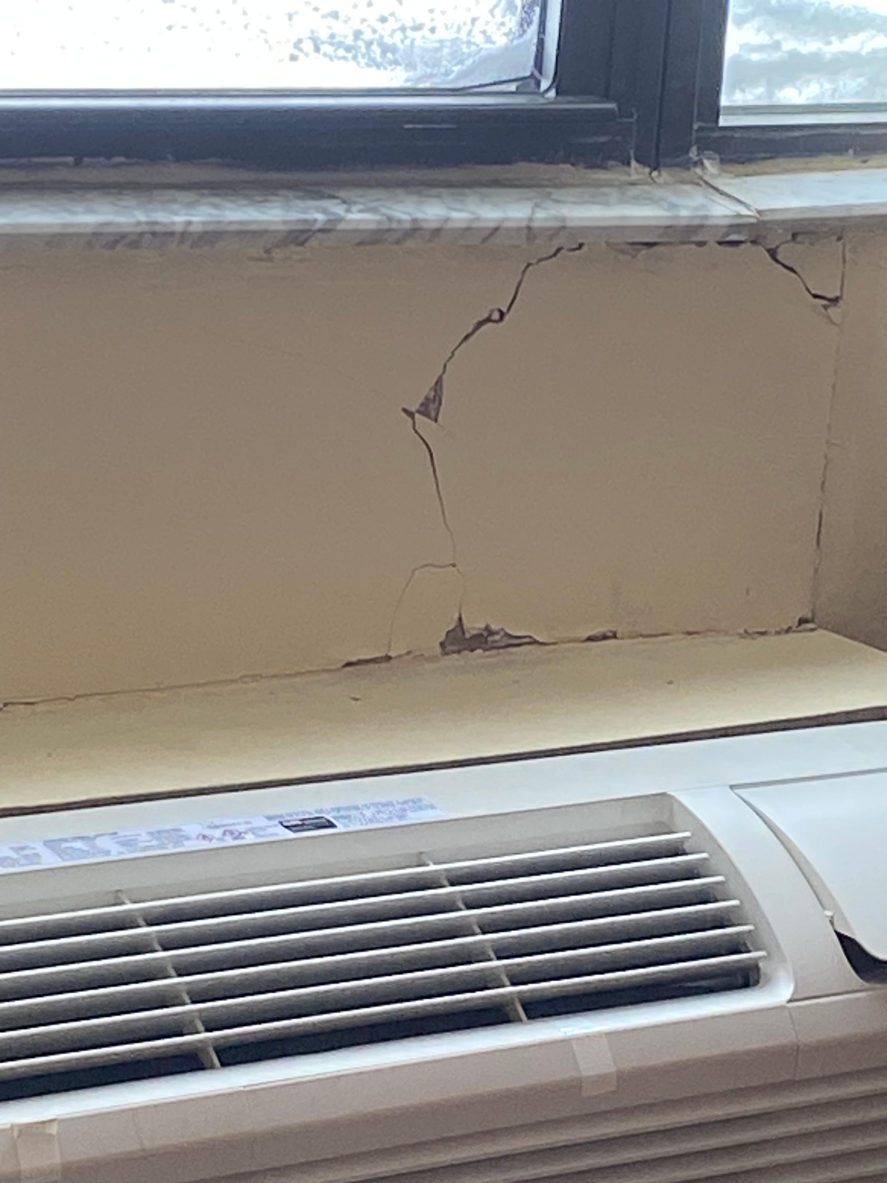 Cracked wall and window sill above very loud heating unit that smelled when it ran 