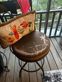 Ripped barstool seats on screened in porch.