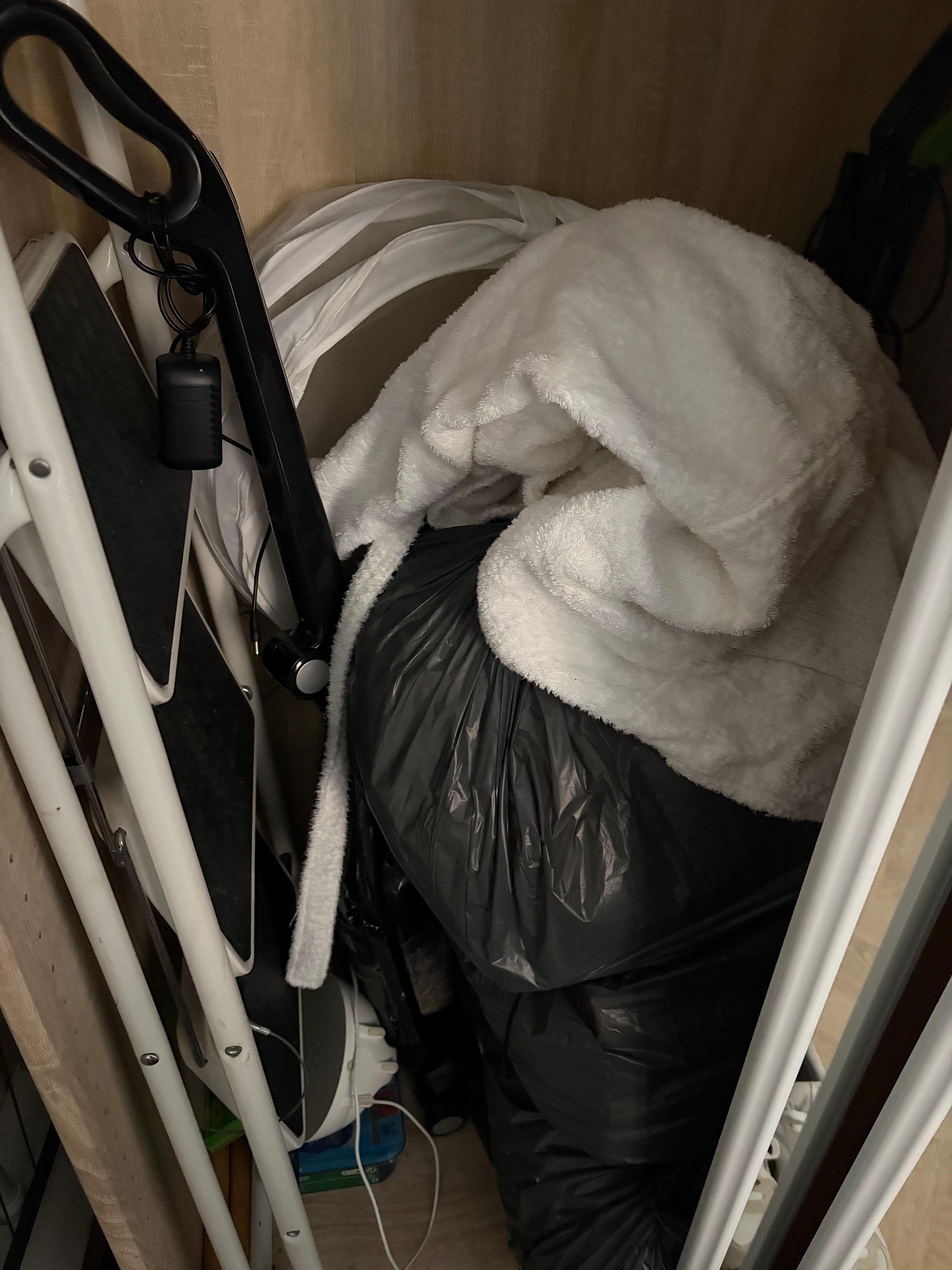 Trash and dirty laundry stuffed into closet 