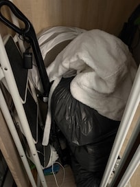 Trash and dirty laundry stuffed into closet