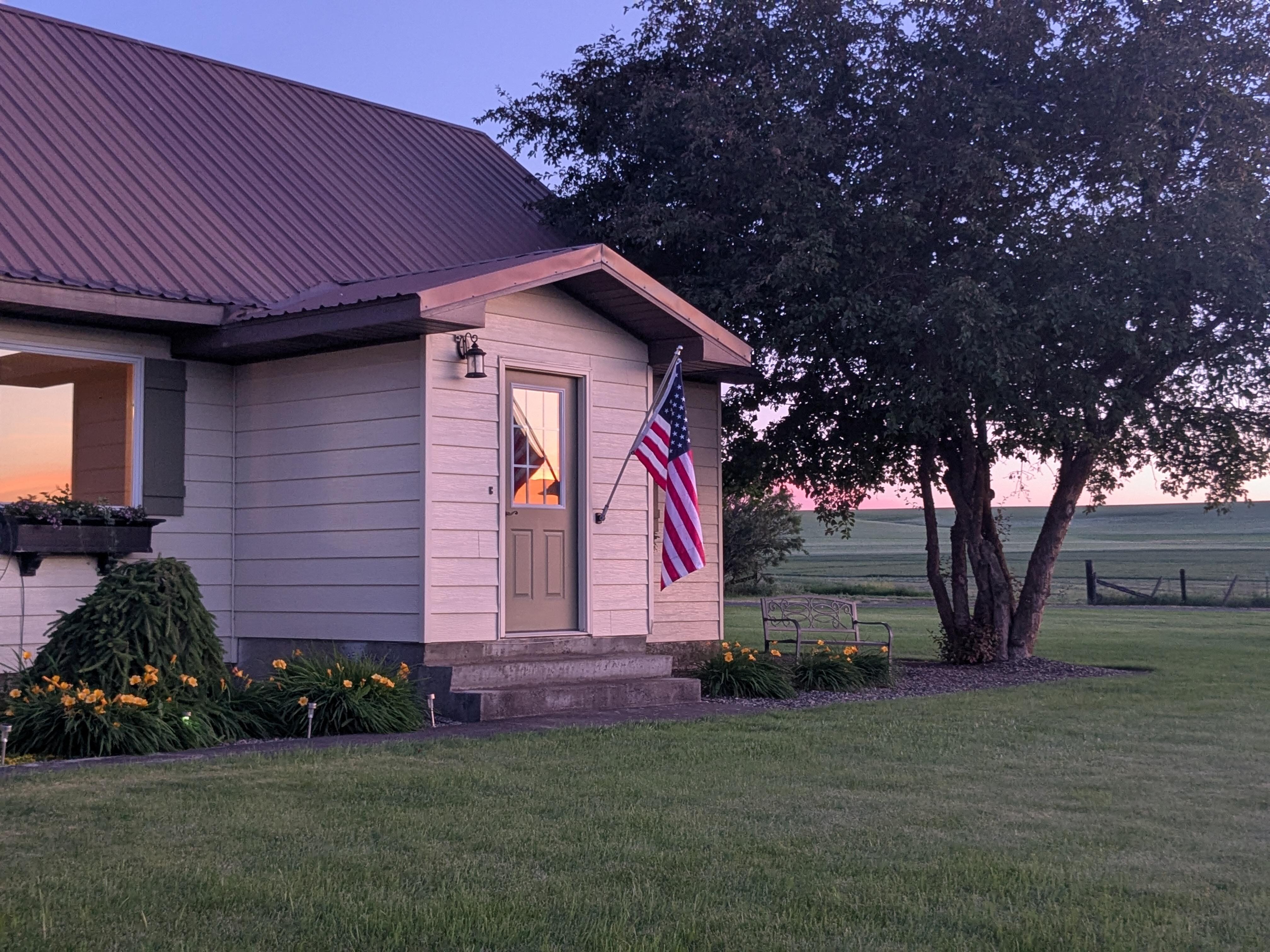 The front of the house bathed in pink glow from the sunset.