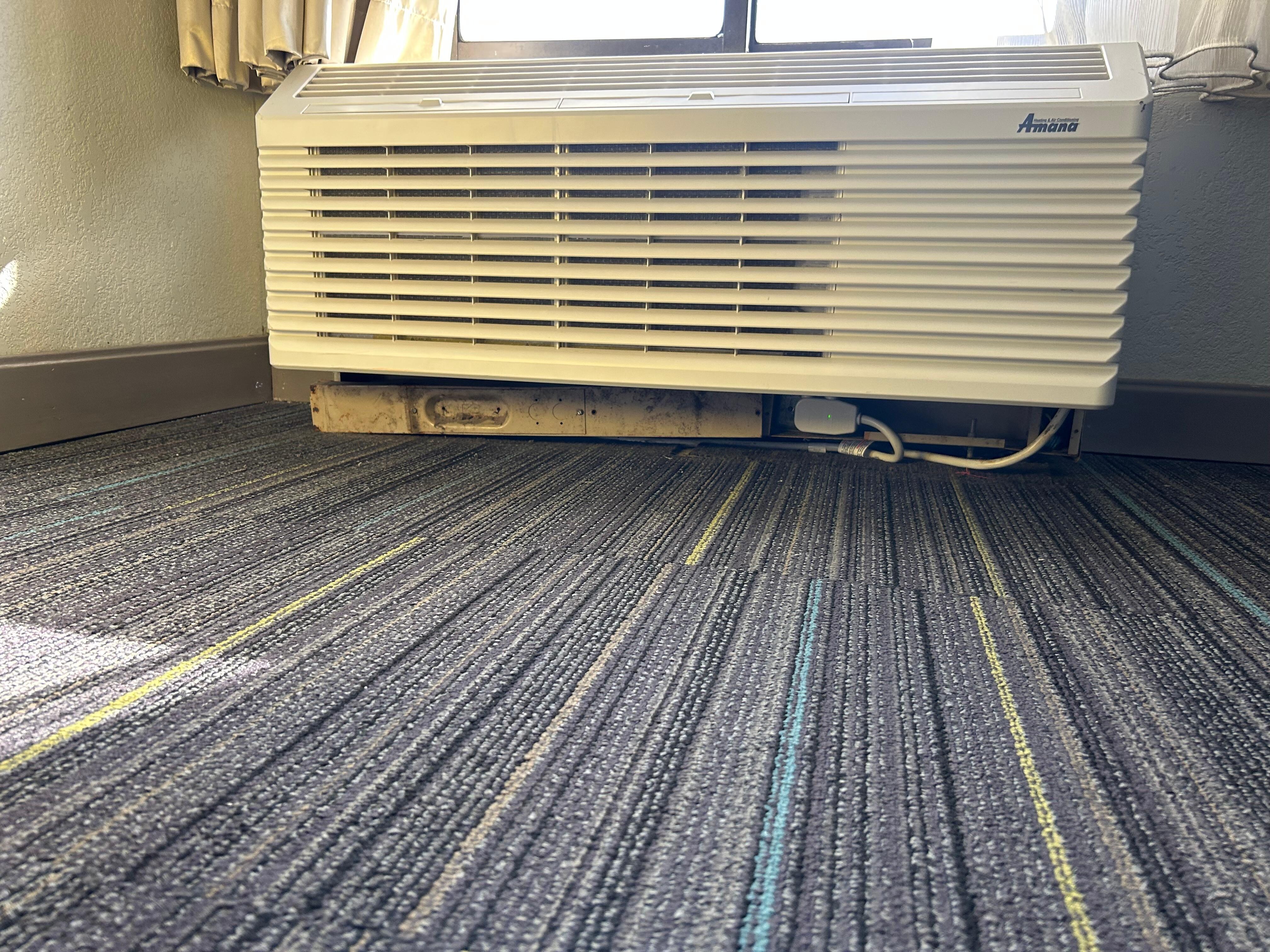 AC unit propped up with a peice of wood