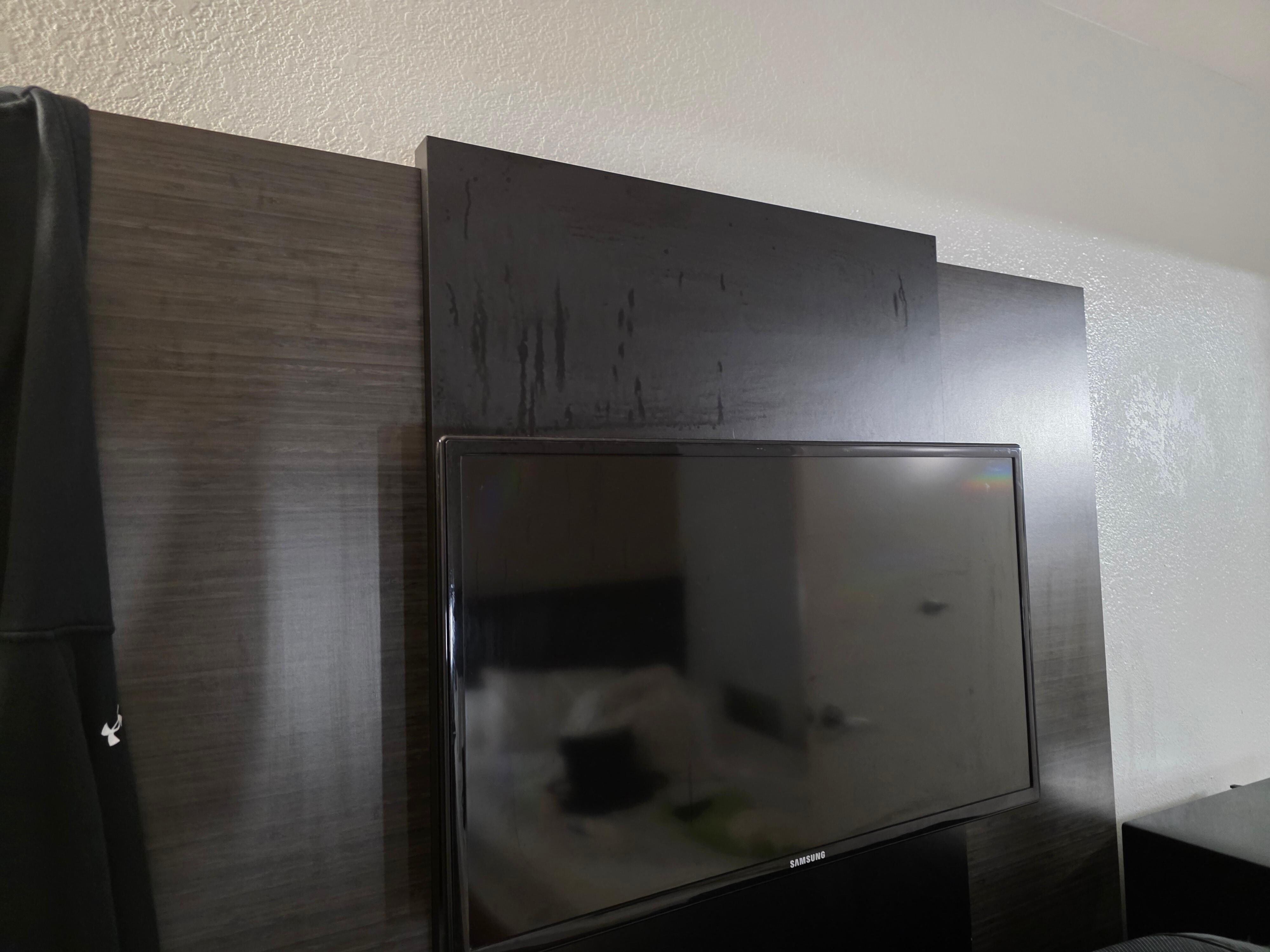 Something gross left all over wall behind tv