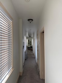 Long hallway between the living room and kitchen, with bedrooms to the right.