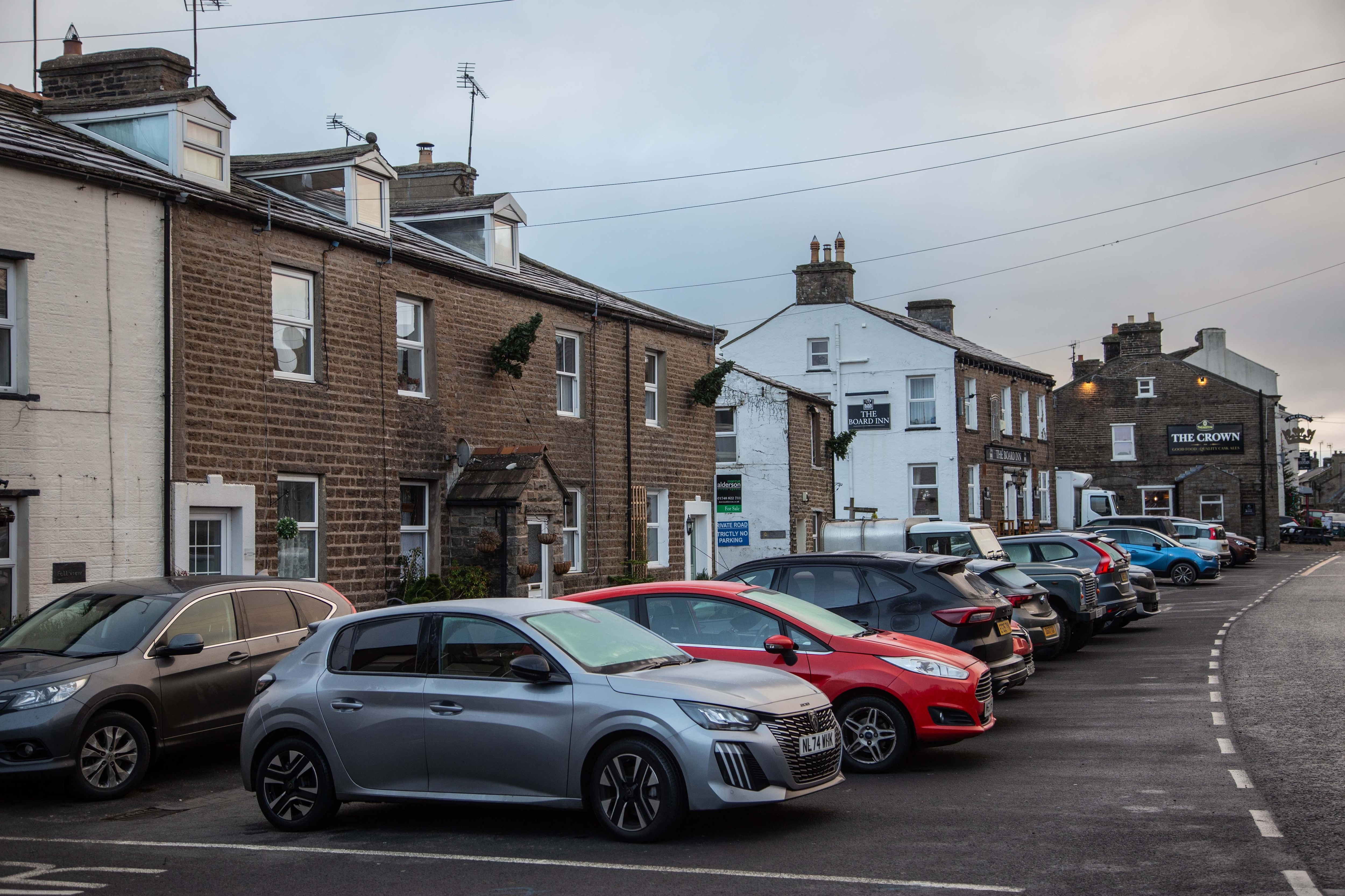 This cottage has the white door.  Two pubs are within one hundred yards!