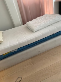 Smutsig, trasig resårmadrass direkt på golvet med två udda dåliga madrasser ovanpå