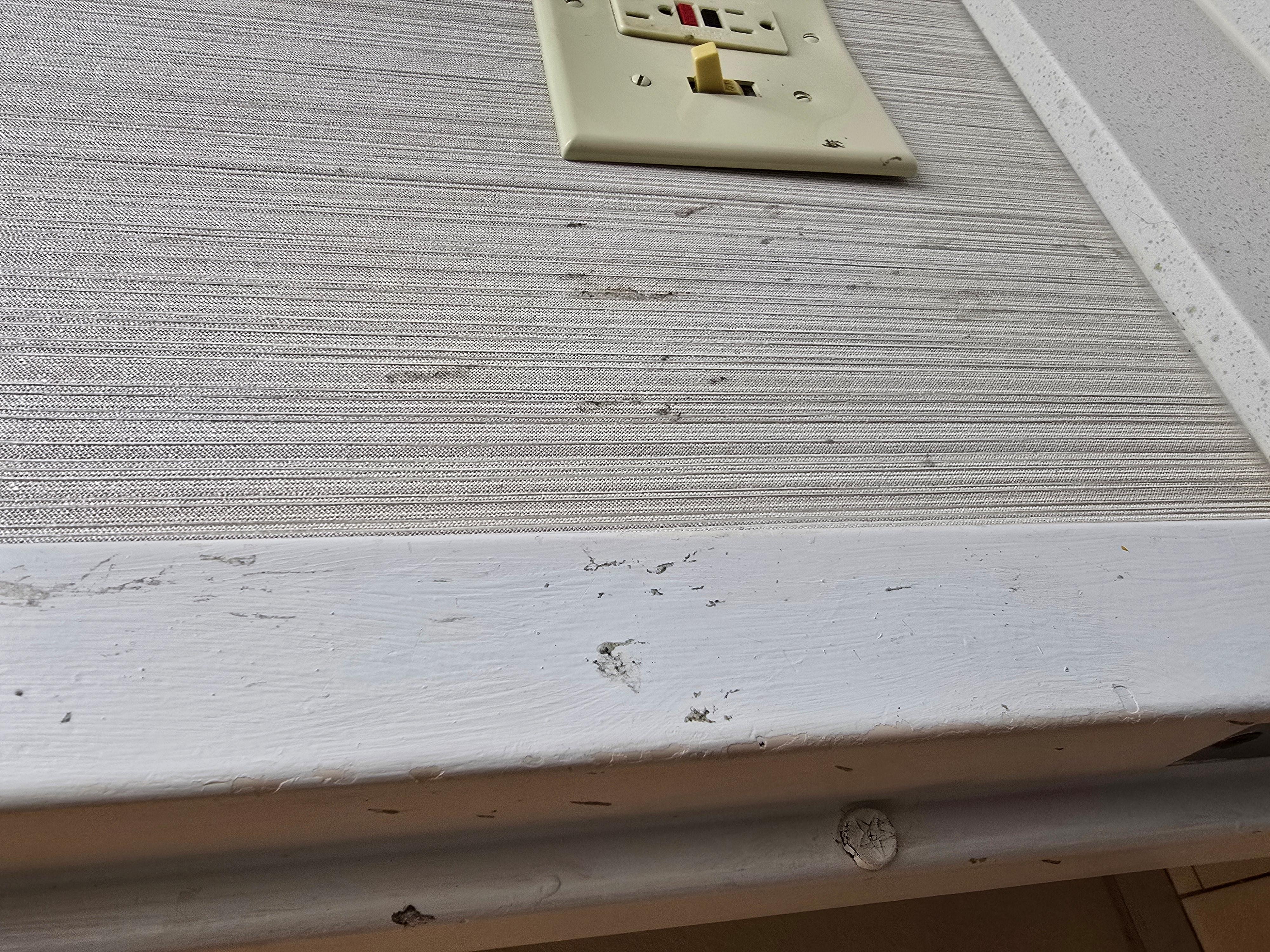 Gross junk on bathroom wall.