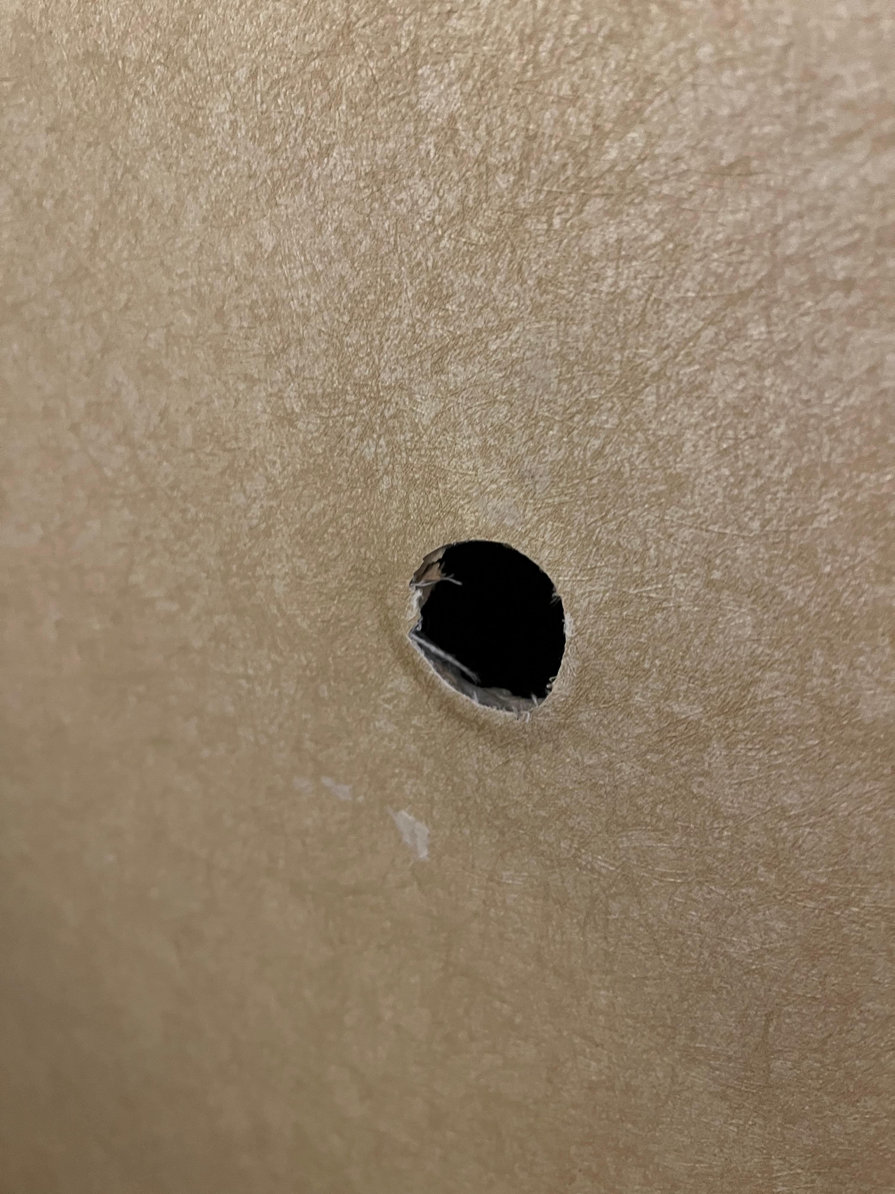 Hole on wall next to bed