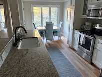 Big kitchen with toaster, coffee pot, keurig, seasonings, fridge, oven, dishwasher.