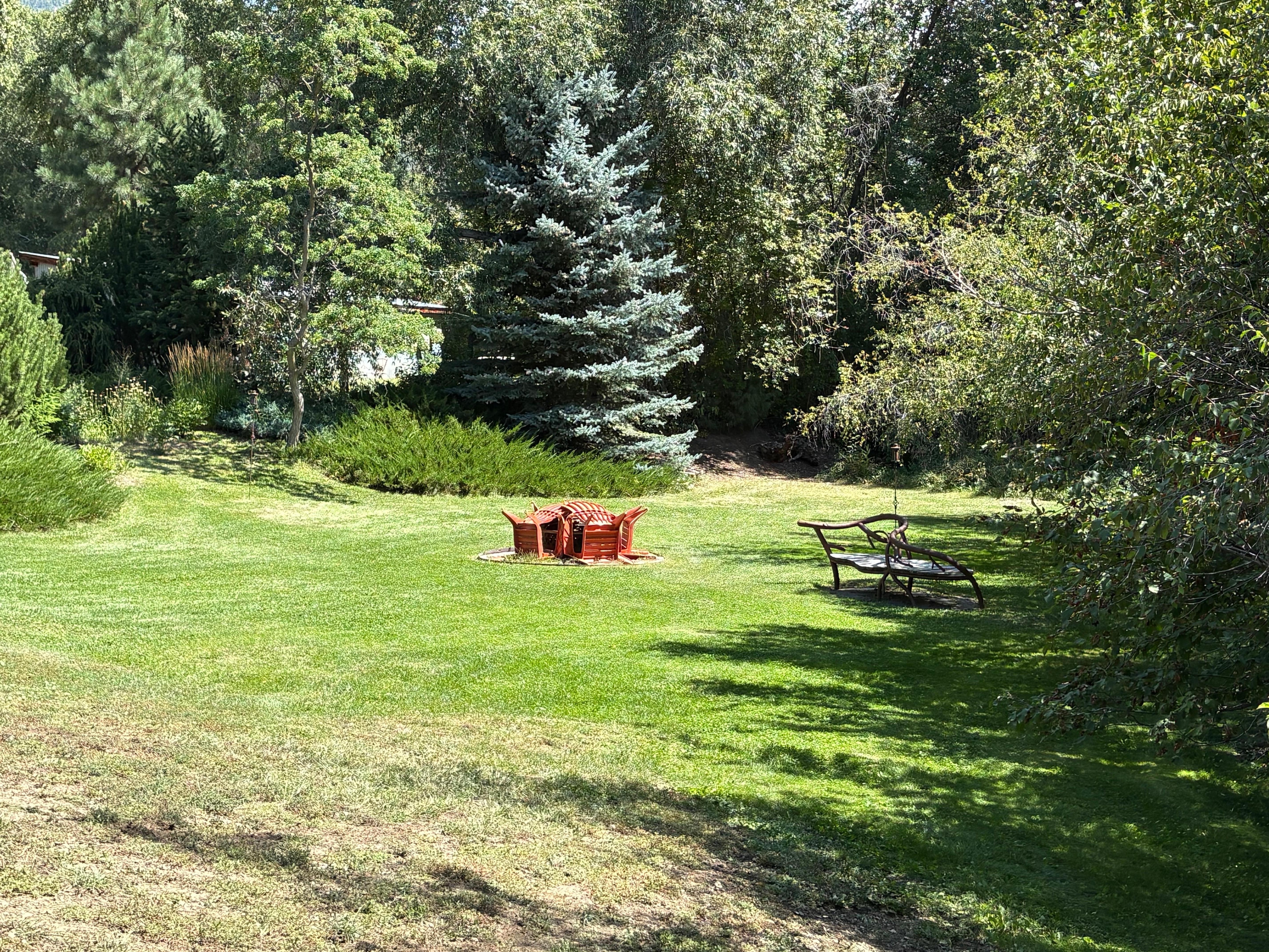 Other side of pond bridges with seats by brook.