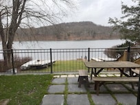 View of lake from fenced yard with picnic table hot tub and dog area