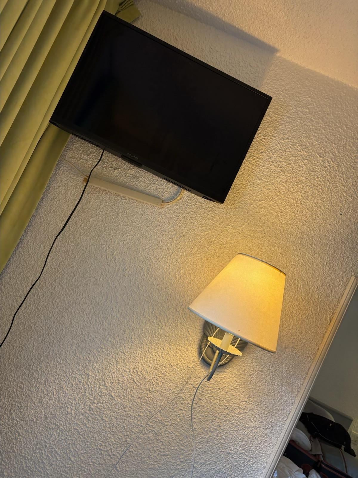 Tv in the corner with wires hanging down. 