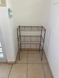 Rusty wire rack that serves as a "closet"