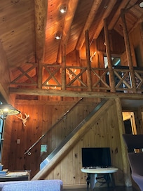 Stairs to upstairs bedroom with private bath. Zoom in to check out the deer antler lamps along the stairs!