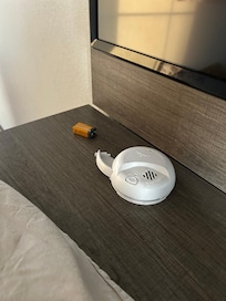 Smoke detector off wall and lying on dresser.
