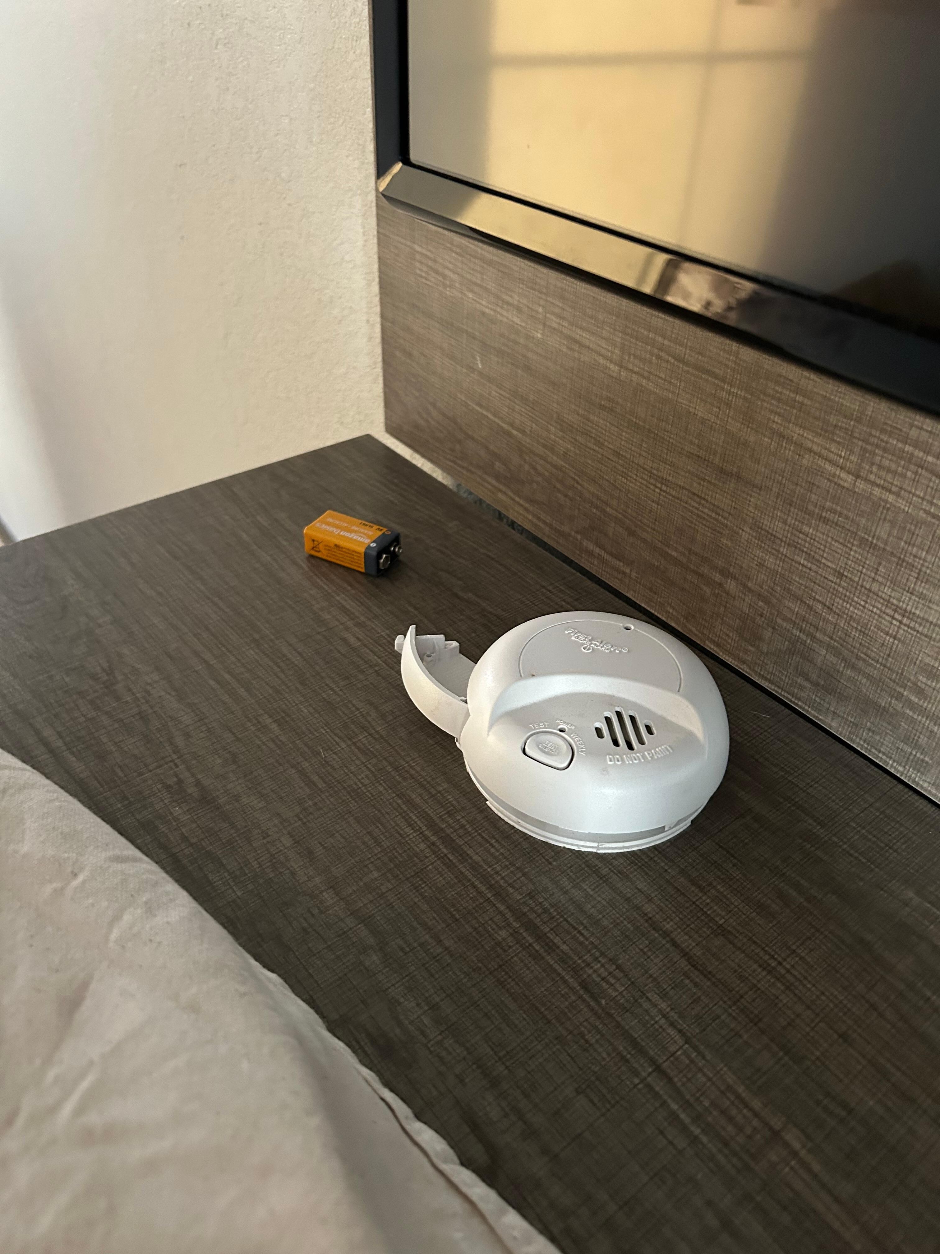 Smoke detector off wall and lying on dresser.