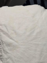 Yellow pillow case staining, like shape of a head or face