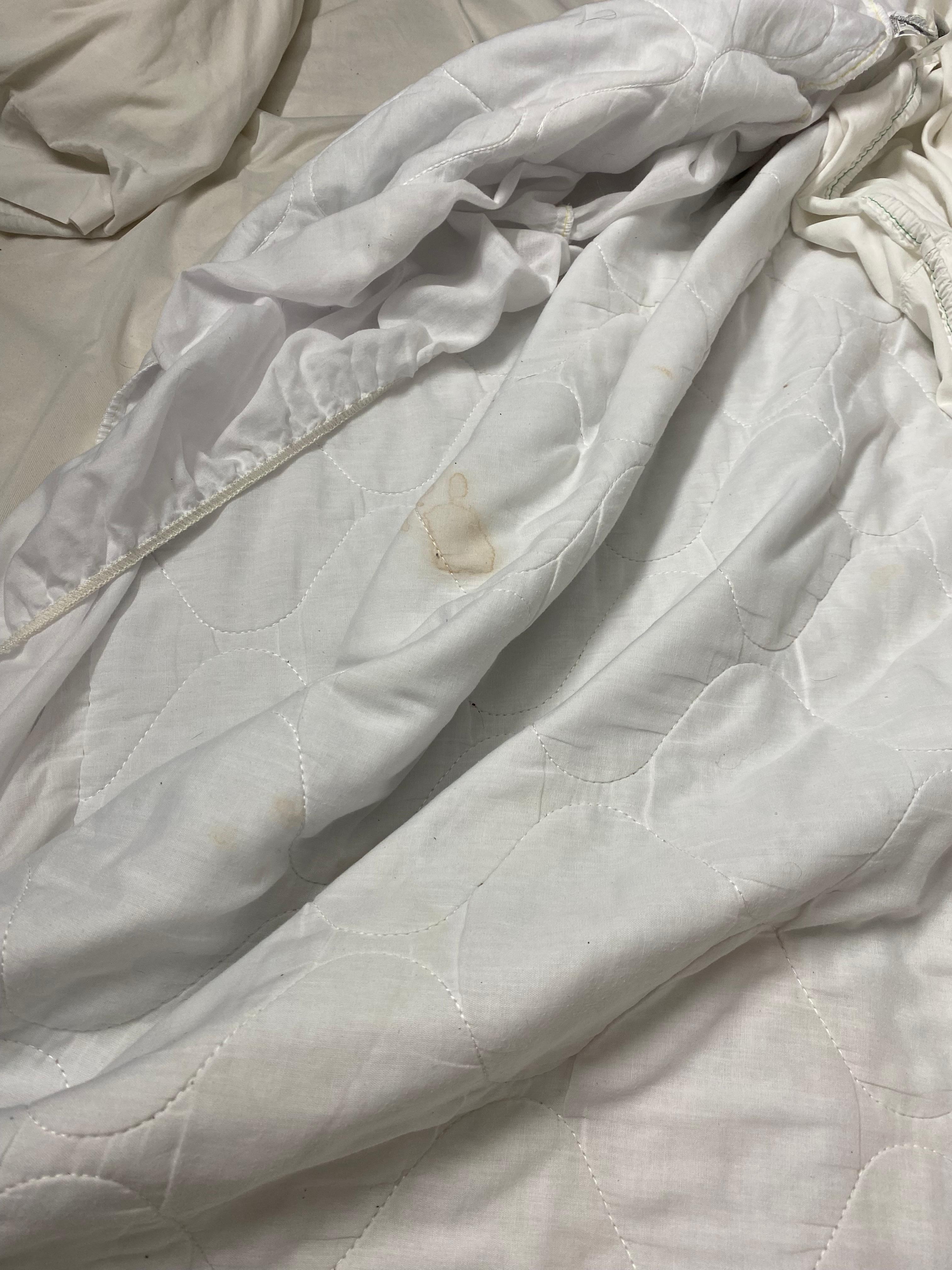 Mattress pad cover stained with what it looks like blood.
