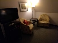 Poltroncine e TV fronte letto