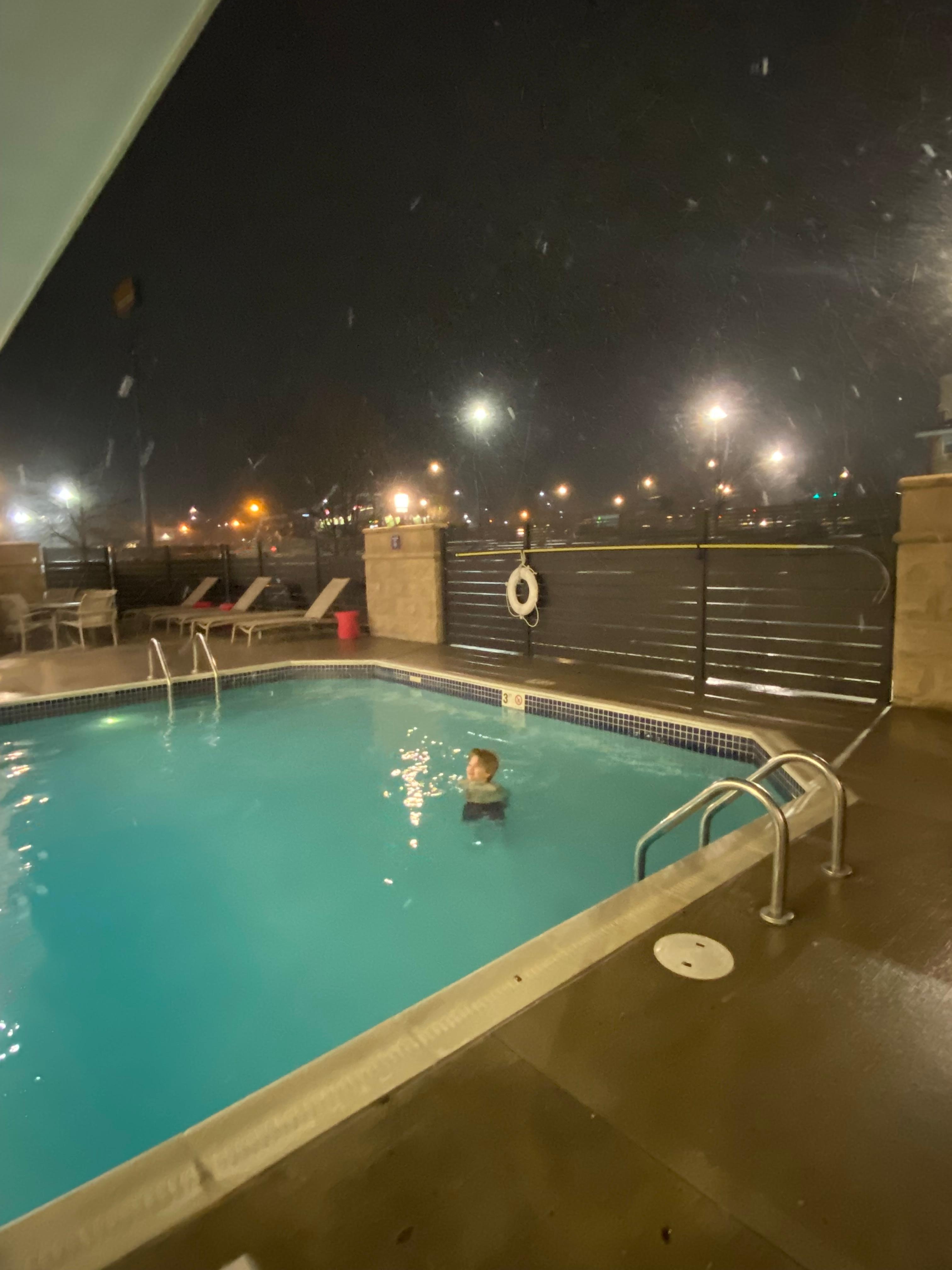 Swimming outside while snow is falling.