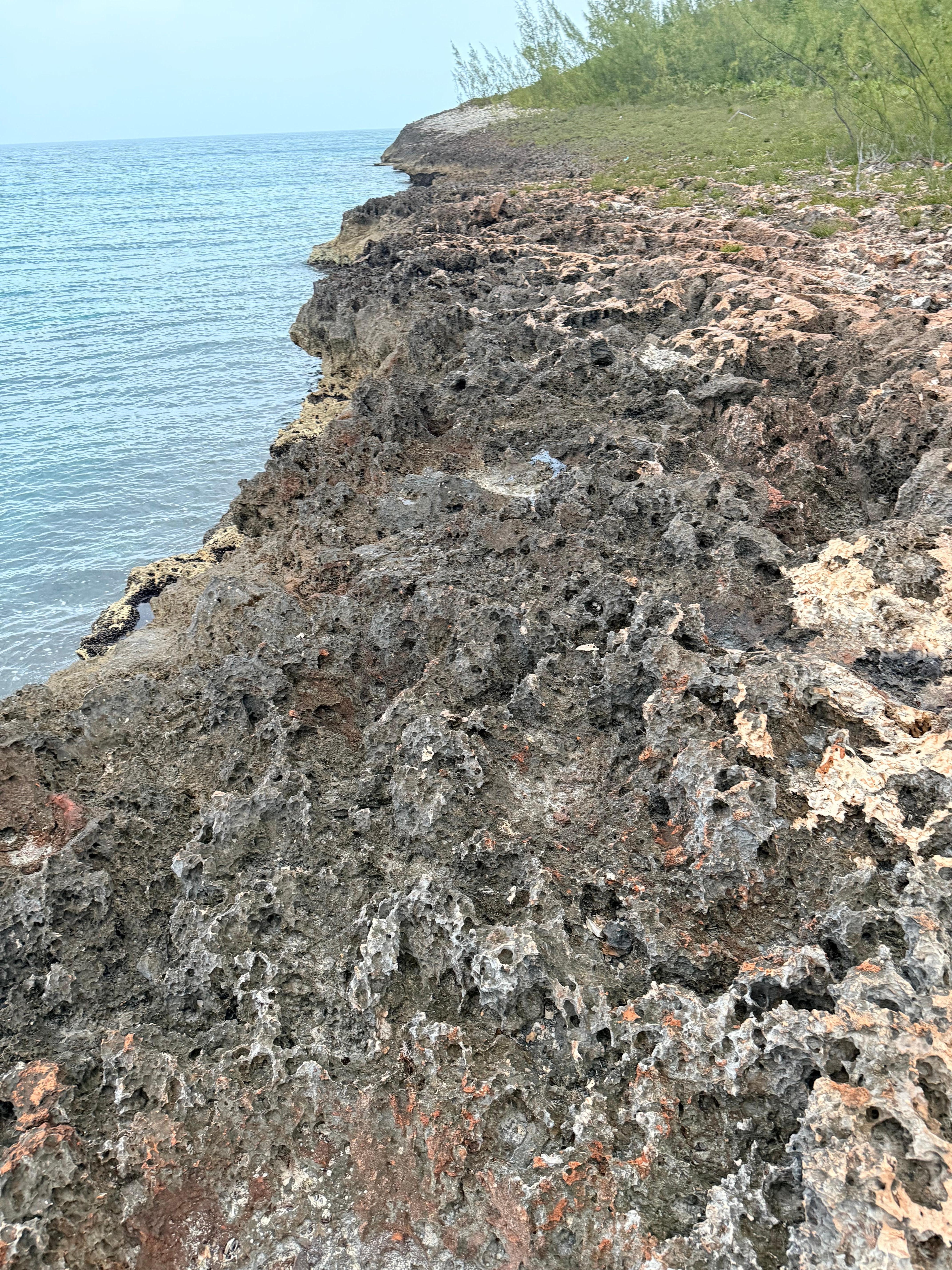 Rocky shoreline at the end of the road next to the dock. 